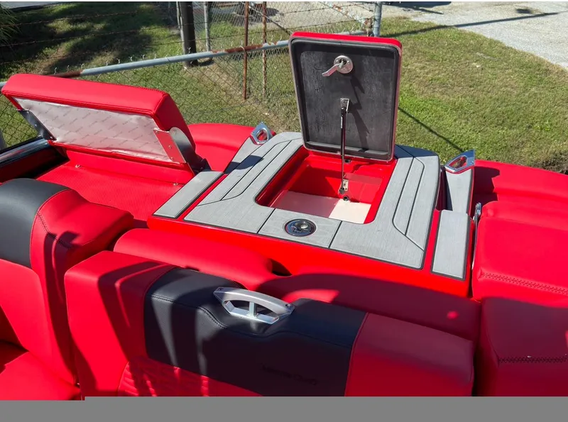 Slide: The Image of 2020 MasterCraft X24 boat with red and black seating and storage compartment. - 12