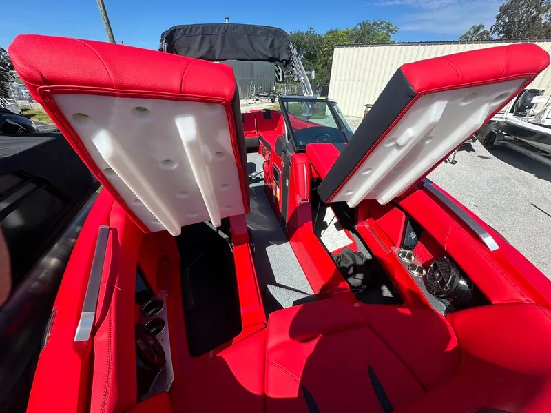 Slide: The Image of 2020 MasterCraft X24 boat with red interior and open storage compartments. - 24
