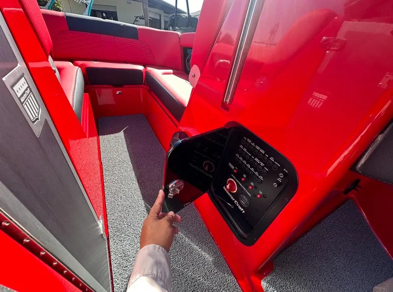 Slide: The Image of 2020 MasterCraft X24 boat interior with red upholstery and control panel. - 27
