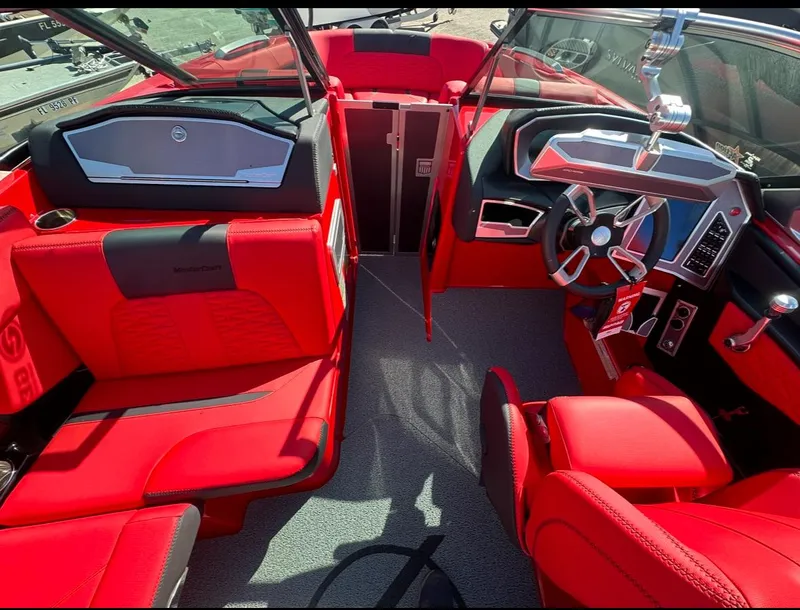Slide: The Image of 2020 MasterCraft X24 boat interior with red upholstery and modern dashboard. - 29
