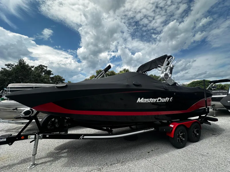 Slide: The Image of 2020 MasterCraft X24 boat with black and red design on a trailer. - 4