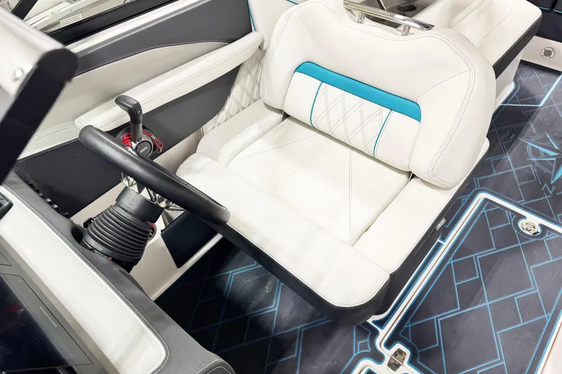 Slide: The Image of 2023 Regal LS6 boat interior with white and blue seating, modern steering, and stylish flooring. - 14