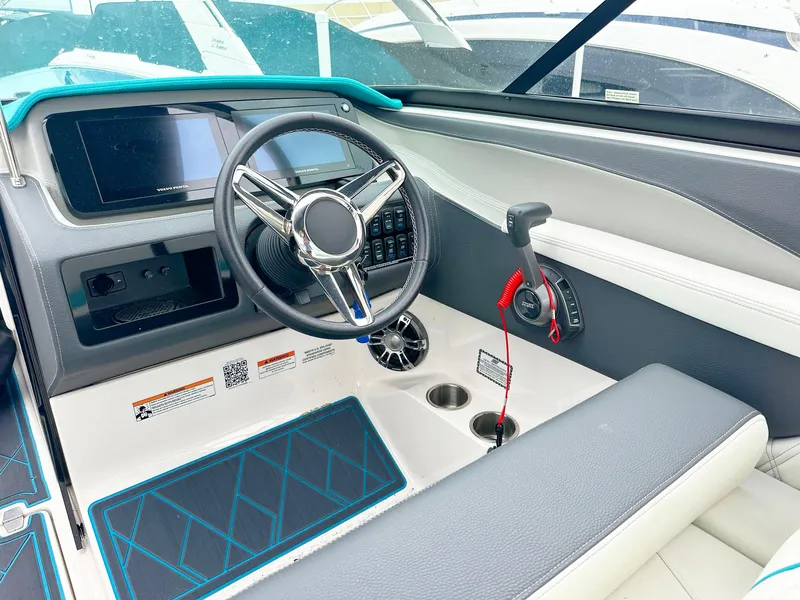 Slide: The Image of 2023 Regal LS6 boat cockpit with steering wheel, control panel, and throttle lever. - 7