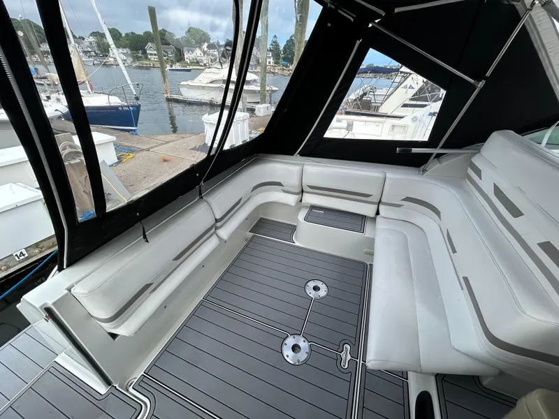 Slide: The Image of 2000 Formula 34 PC boat interior with white seating and marina view. - 16