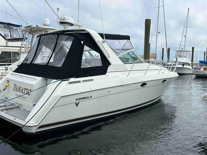 Slide: The Image of 2000 Formula 34 PC yacht docked in marina, featuring sleek design and black canopy. - 2