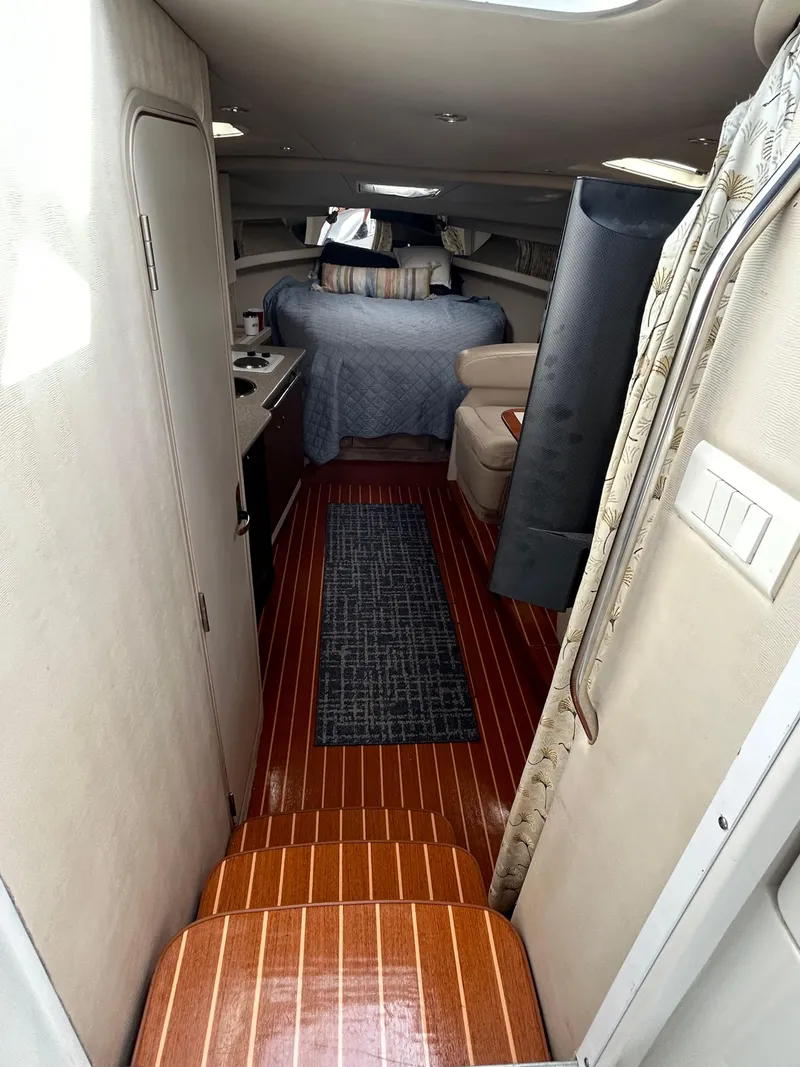 Slide: The Image of Interior of a 2000 Formula 34 PC boat with wood flooring and cozy sleeping area. - 27