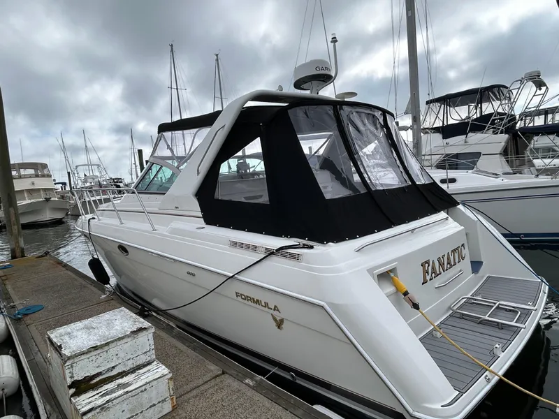 Slide: The Image of 2000 Formula 34 PC boat docked at marina, featuring sleek design and black canopy. - 3