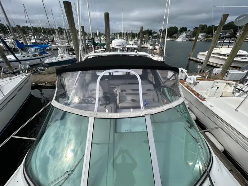 Slide: The Image of 2000 Formula 34 PC boat docked at marina with clear canopy and surrounding yachts. - 5