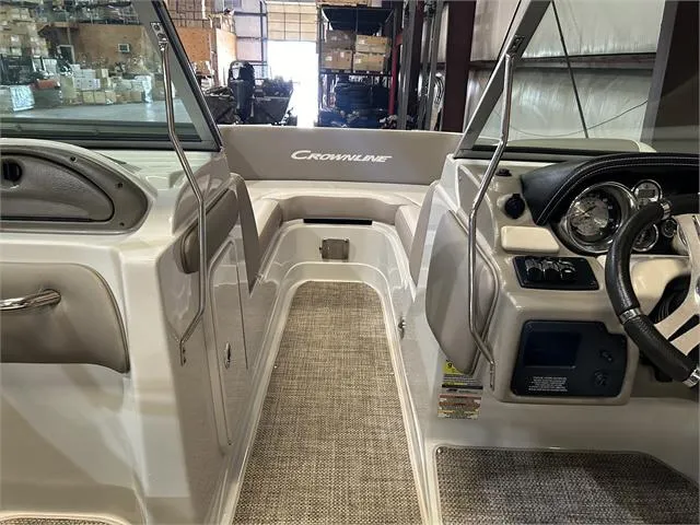 Slide: The Image of 2018 Crownline E21X boat interior with steering wheel and seating area. - 10