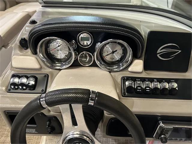 Slide: The Image of 2018 Crownline E21X boat dashboard with steering wheel, gauges, and control switches. - 14
