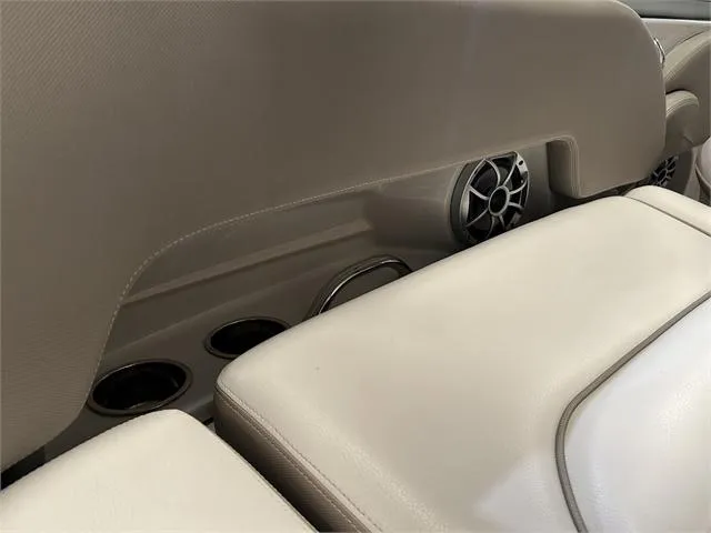 Slide: The Image of 2018 Crownline E21X boat interior with beige seating and built-in speakers. - 21