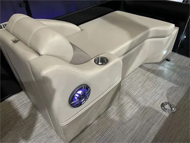 Slide: The Image of 2024 Veranda VR22RFL W/Yamaha 150 boat interior with beige seating and built-in speaker. - 16