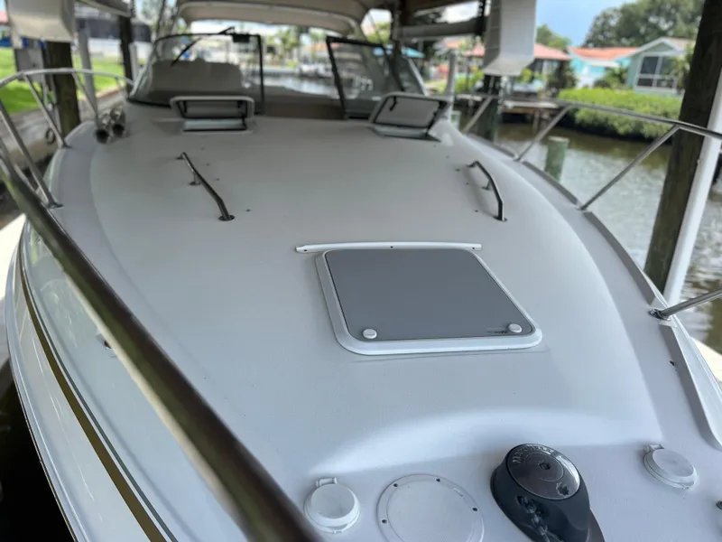 Slide: The Image of 2004 Larson 330 boat deck with hatches and railings in a marina. - 10
