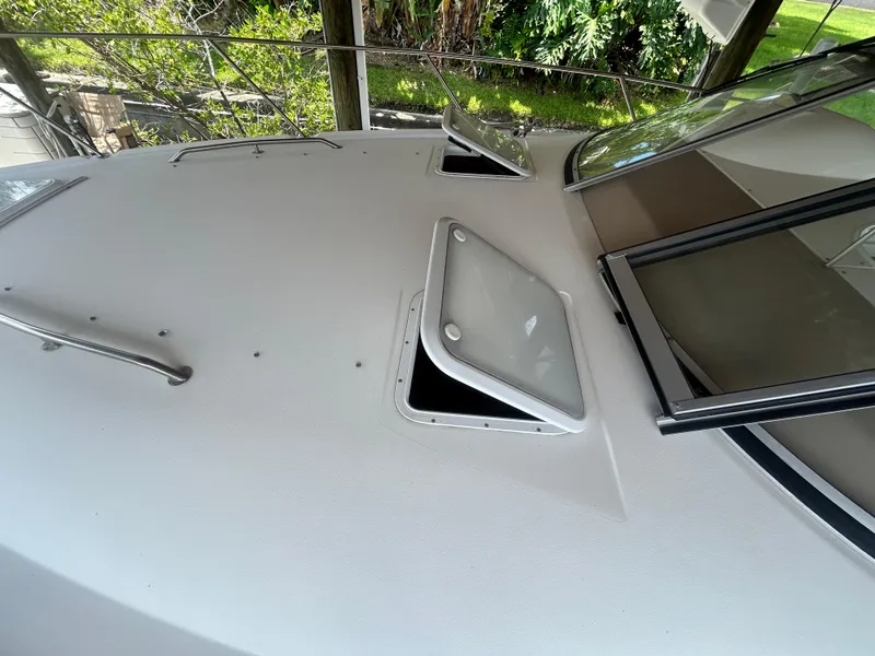 Slide: The Image of 2004 Larson 330 boat deck with open hatches and windows. - 13