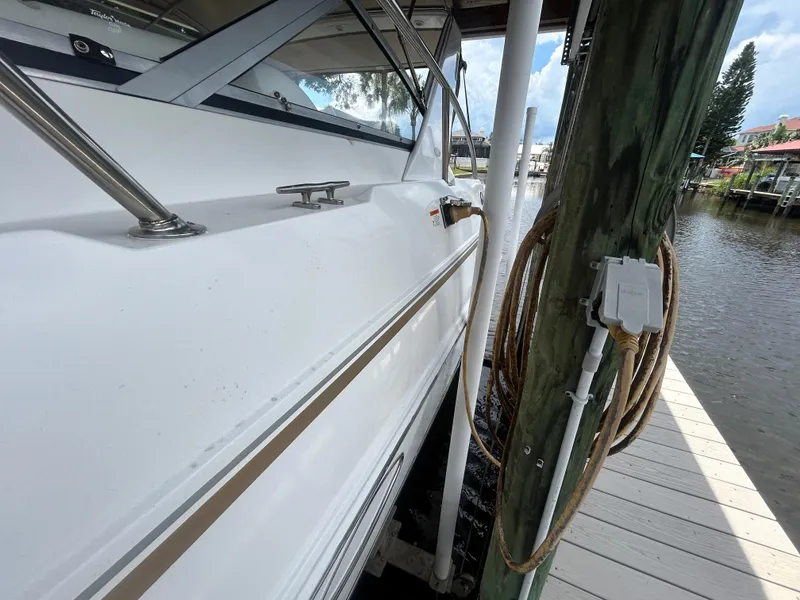 Slide: The Image of 2004 Larson 330 boat docked at marina with water and sky in background. - 15