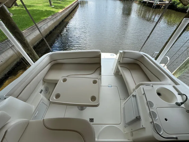 Slide: The Image of 2004 Larson 330 boat interior with seating and table by the water. - 24