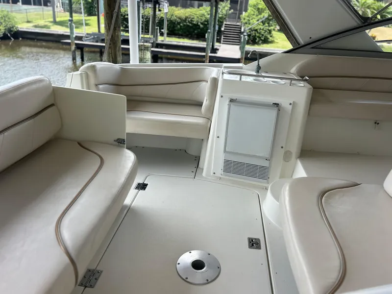 Slide: The Image of Interior of a 2004 Larson 330 boat with white leather seating and a small refrigerator. - 26