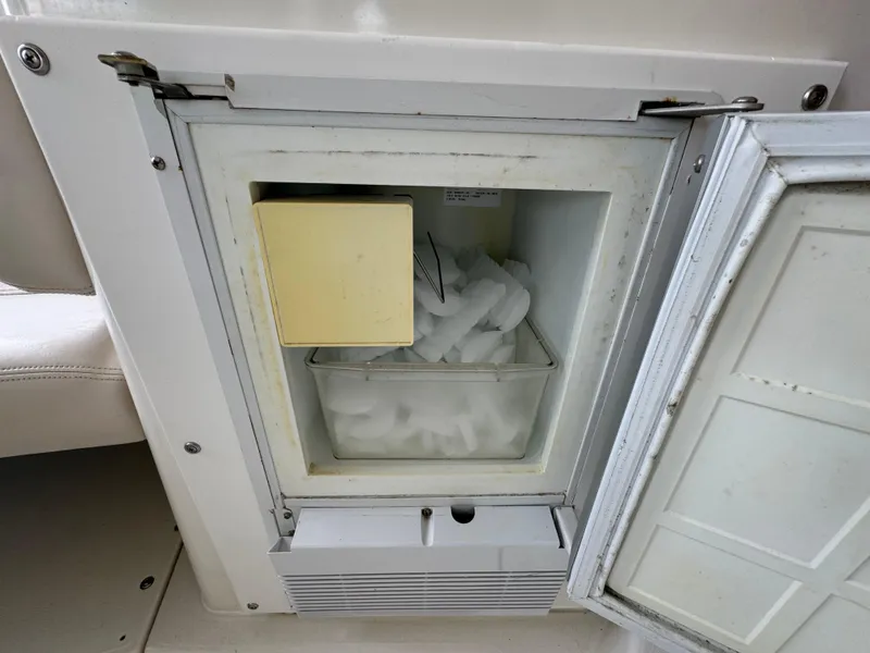 Slide: The Image of Open ice maker on a 2004 Larson 330 boat, showing ice compartment. - 27