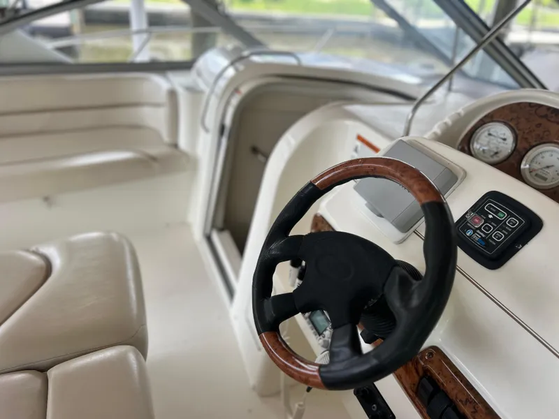 Slide: The Image of 2004 Larson 330 boat interior with steering wheel and dashboard. - 29