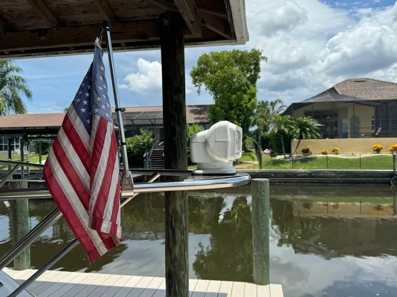 Slide: The Image of American flag on a 2004 Larson 330 boat docked by a canal. - 3