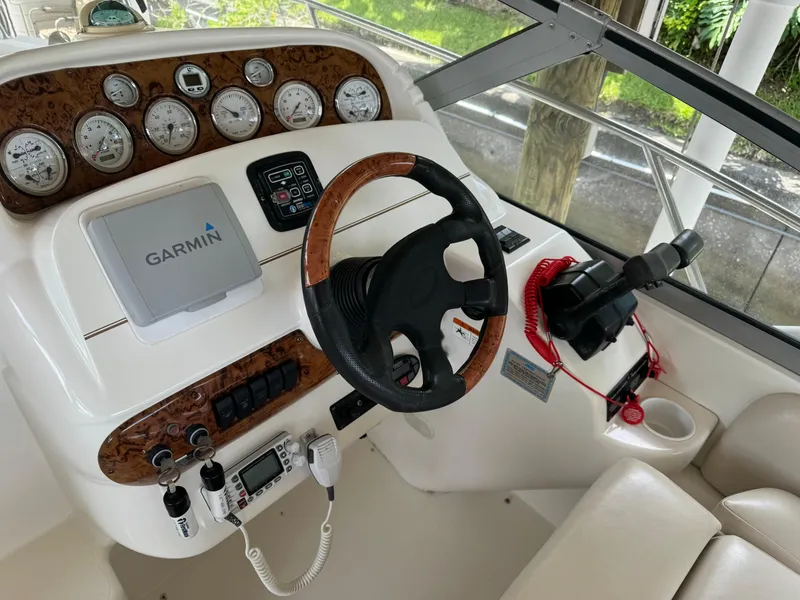 Slide: The Image of 2004 Larson 330 boat helm with Garmin navigation, wood-trimmed dashboard, and steering wheel. - 30