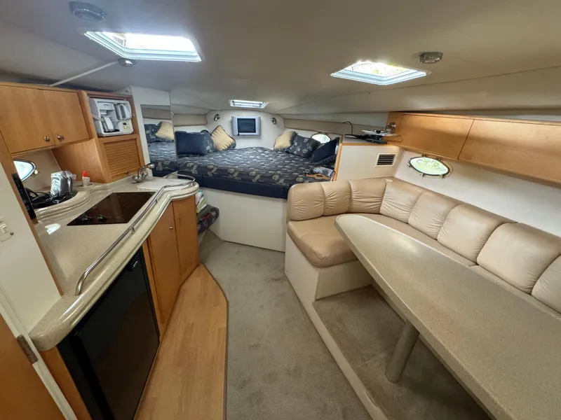Slide: The Image of Interior of a 2004 Larson 330 boat with kitchen, seating, and sleeping area. - 38