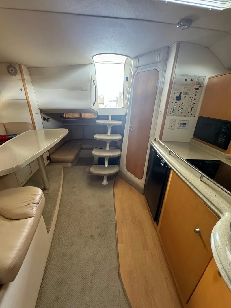 Slide: The Image of 2004 Larson 330 boat interior with kitchen, seating, and stairs. - 39