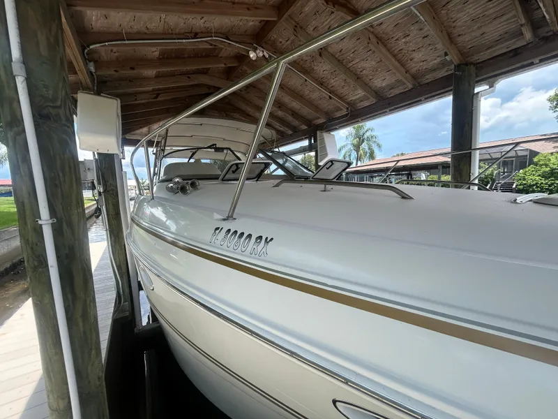 Slide: The Image of 2004 Larson 330 boat docked under a wooden shelter. - 4