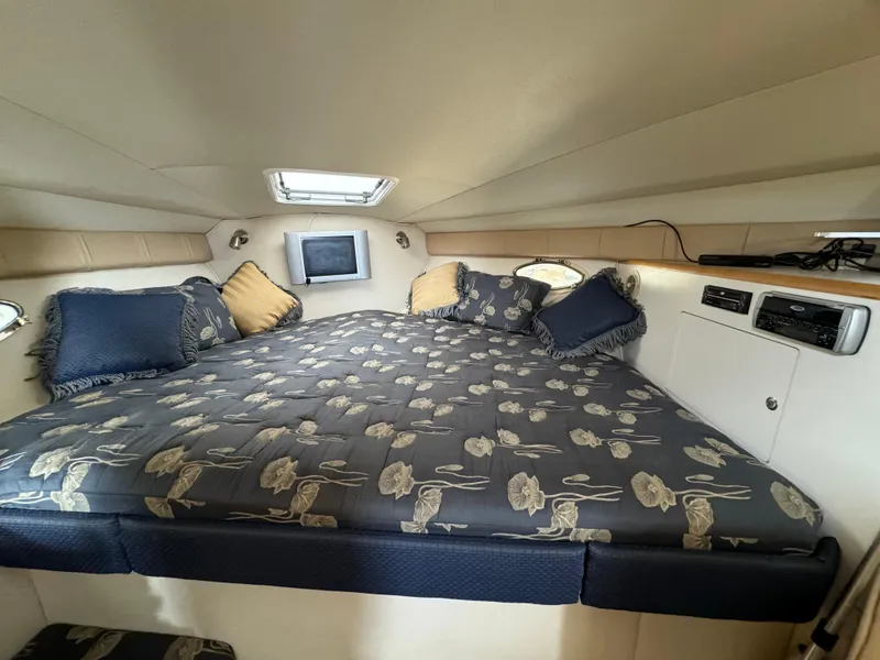 Slide: The Image of 2004 Larson 330 boat cabin with a cozy bed and floral bedding. - 40