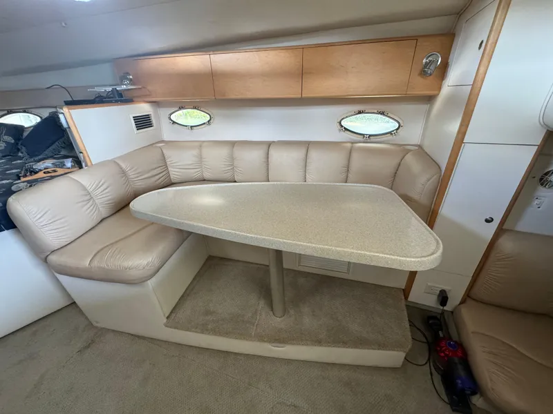 Slide: The Image of 2004 Larson 330 boat interior with beige leather seating and dining table. - 43