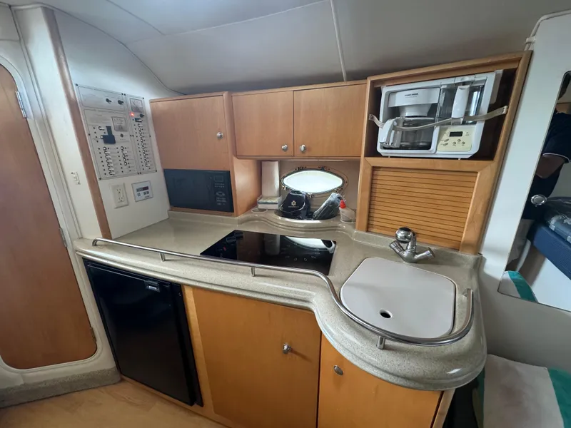 Slide: The Image of 2004 Larson 330 boat kitchen with stove, sink, and microwave. - 44
