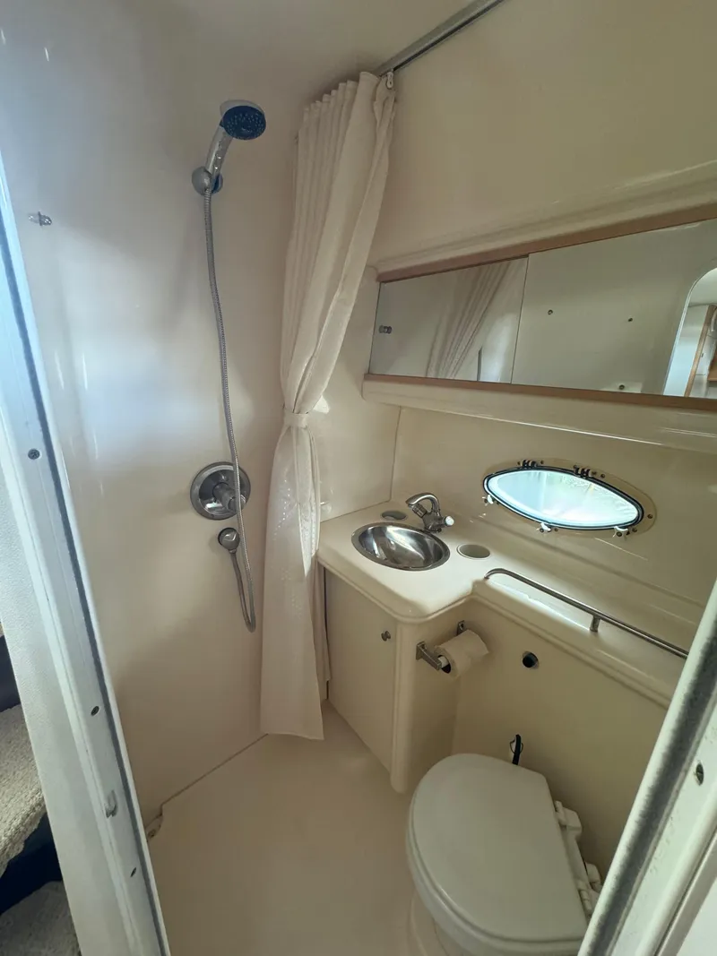 Slide: The Image of 2004 Larson 330 boat bathroom with shower, sink, mirror, and toilet. - 49