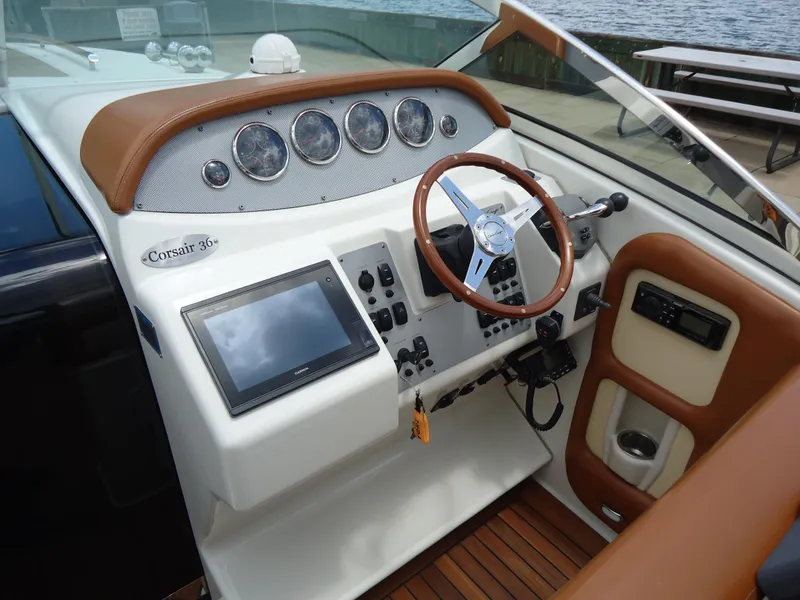 Slide: The Image of 2009 Chris-Craft Corsair 36 boat dashboard with steering wheel and navigation controls. - 21