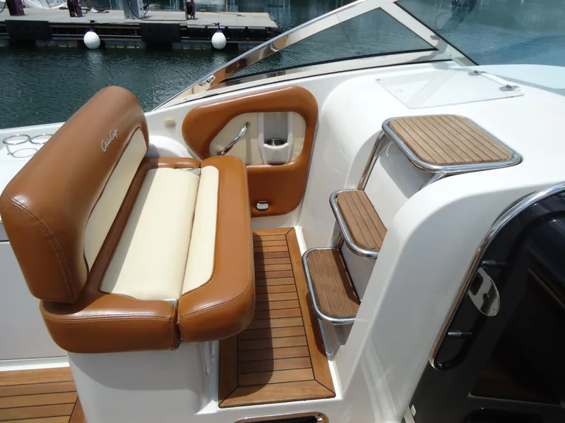 Slide: The Image of 2009 Chris-Craft Corsair 36 boat interior with tan leather seating and wooden steps. - 24