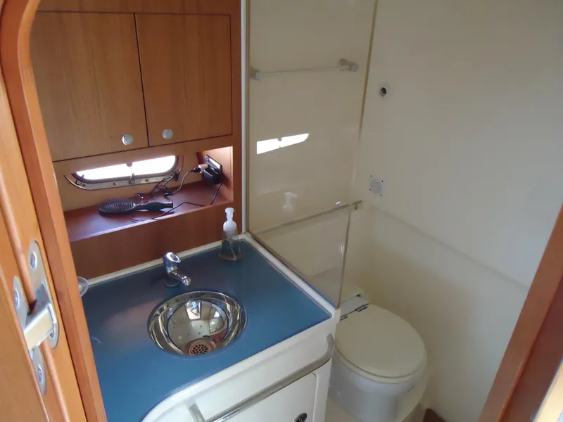 Slide: The Image of 2009 Chris-Craft Corsair 36 bathroom with sink, toilet, and wooden cabinetry. - 25