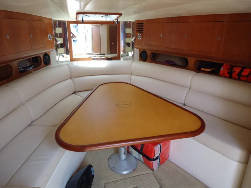 Slide: The Image of 2009 Chris-Craft Corsair 36 interior with white leather seating and wooden table. - 26