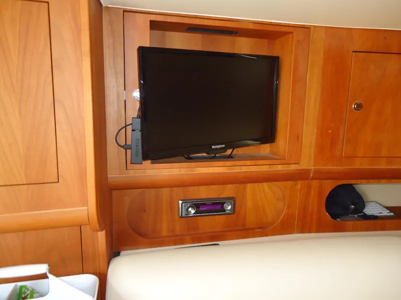 Slide: The Image of 2009 Chris-Craft Corsair 36 interior with mounted TV and wooden cabinetry. - 35