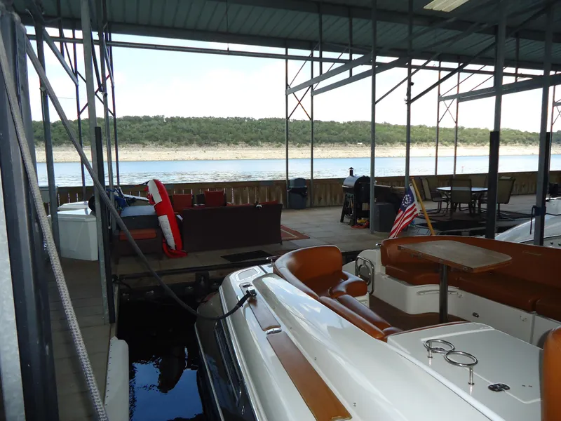 Slide: The Image of 2009 Chris-Craft Corsair 36 docked in a covered marina with lake view. - 37