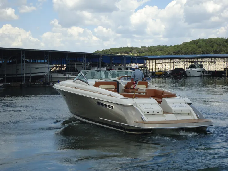Slide: The Image of 2009 Chris-Craft Corsair 36 boat cruising near a marina on a sunny day. - 5