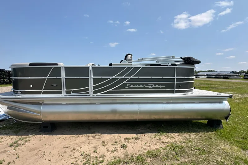 Slide: The Image of 2025 South Bay 220RSLE pontoon boat on grassy area under clear sky. - 0