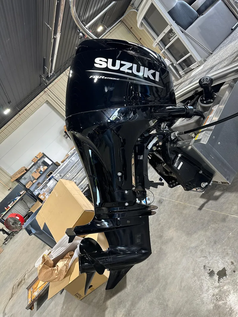 Slide: The Image of 2025 South Bay 220RSLE with Suzuki outboard motor in a workshop. - 13