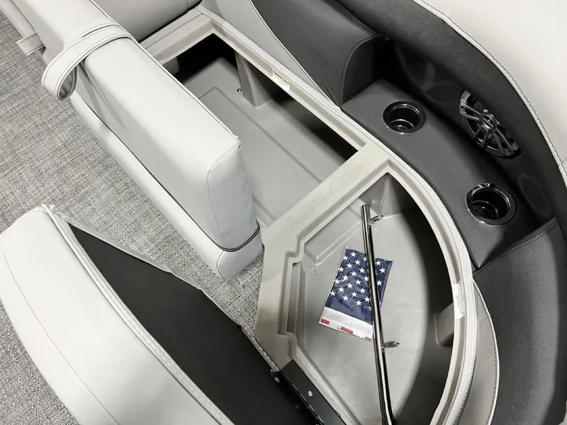 Slide: The Image of 2025 Barletta ARIA A22UC boat interior storage compartment with cup holders and American flag. - 8