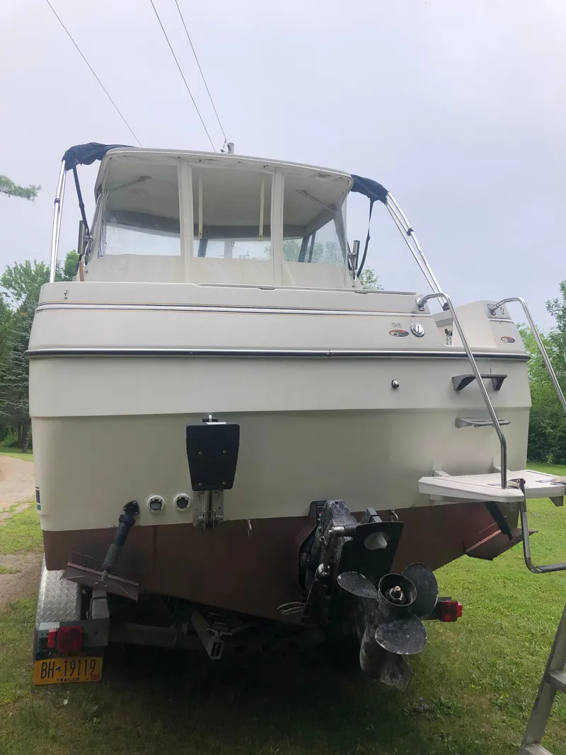 Slide: The Image of 1997 Bayliner Ciera 2452 Express boat, rear view, on trailer, outdoors. - 10