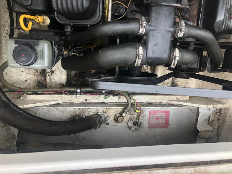 Slide: The Image of Engine compartment of a 1997 Bayliner Ciera 2452 Express boat, showing hoses and components. - 21