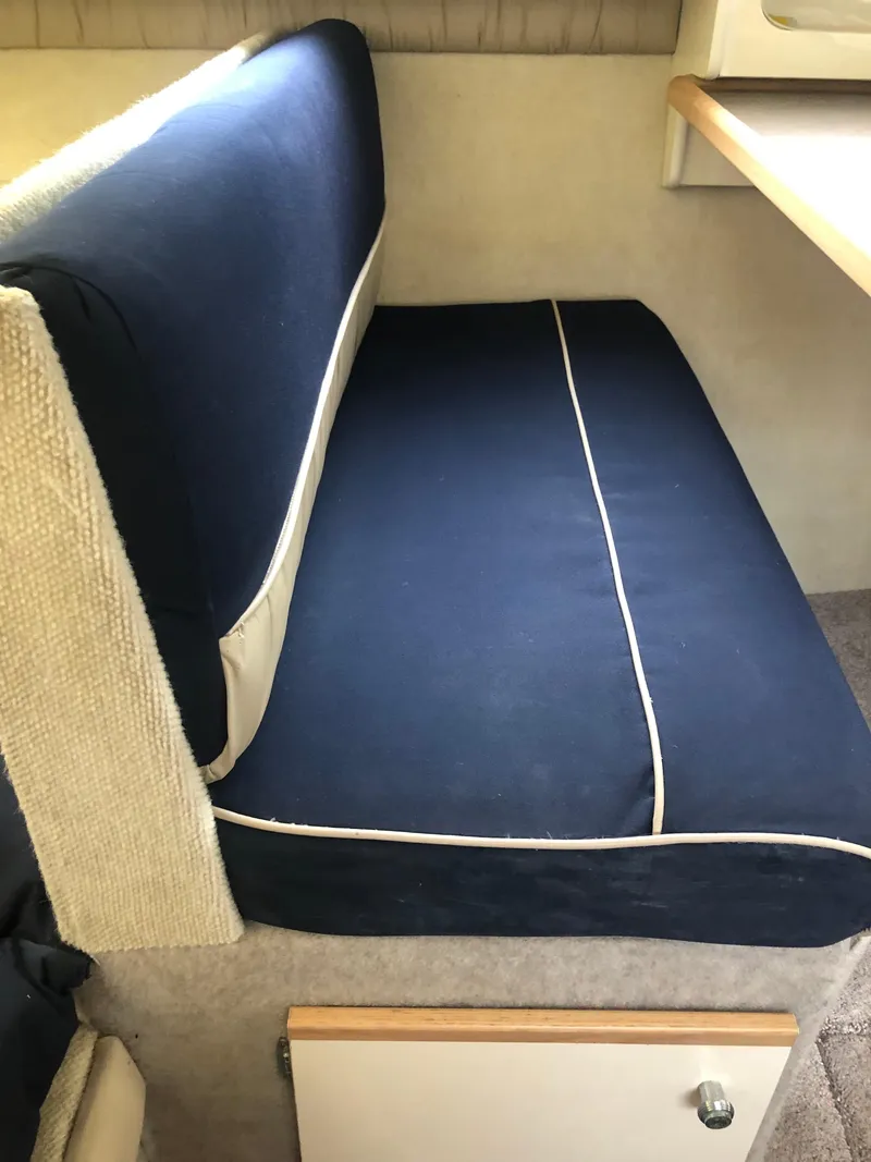 Slide: The Image of 1997 Bayliner Ciera 2452 Express interior with blue cushioned seating and storage. - 47