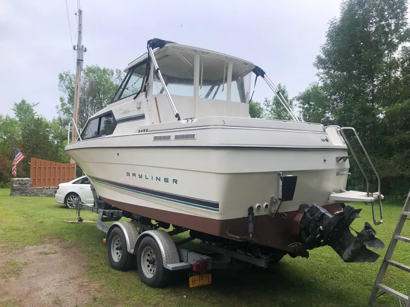 Slide: The Image of 1997 Bayliner Ciera 2452 Express boat on trailer, parked outdoors. - 9