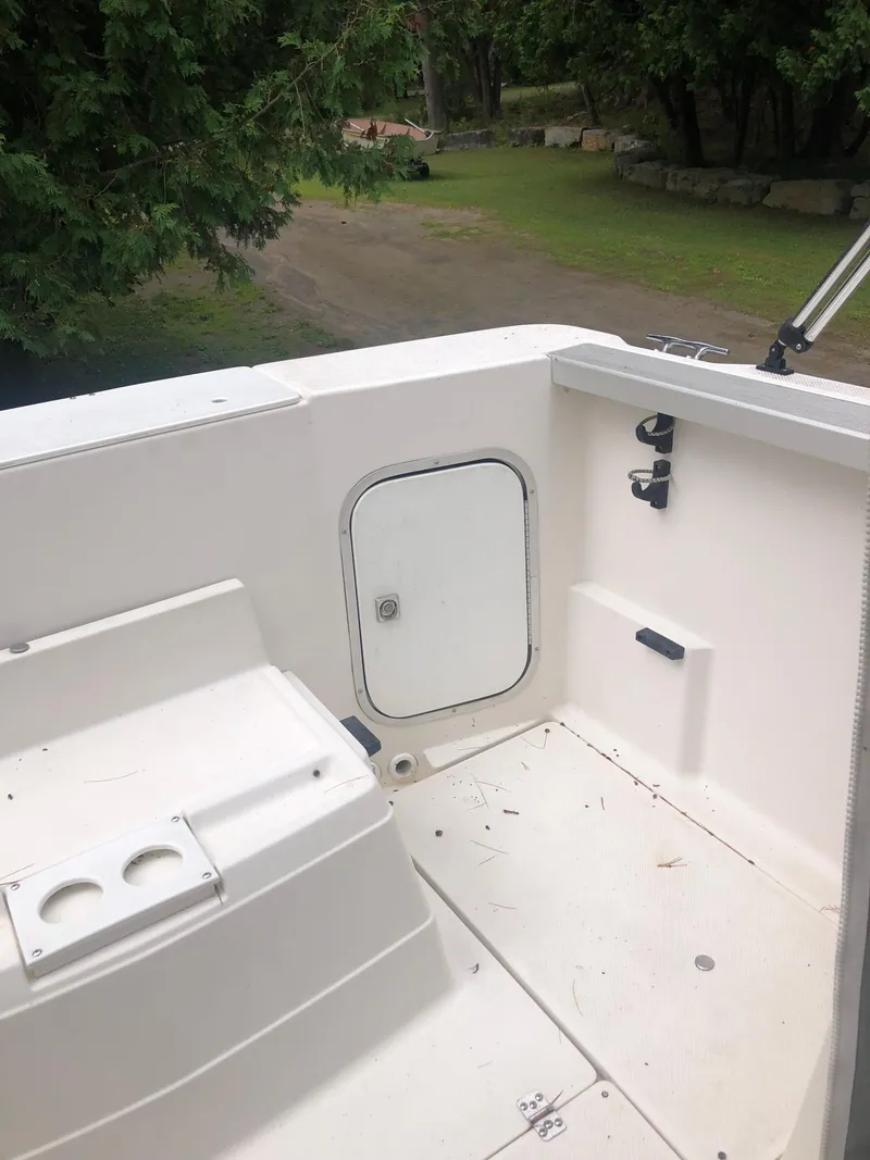 Slide: The Image of 1997 Bayliner Ciera 2452 Express boat deck with storage compartment and seating area. - 16