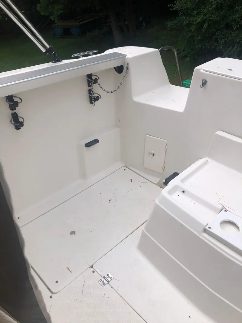 Slide: The Image of 1997 Bayliner Ciera 2452 Express boat deck, featuring clean white surfaces and storage compartments. - 17