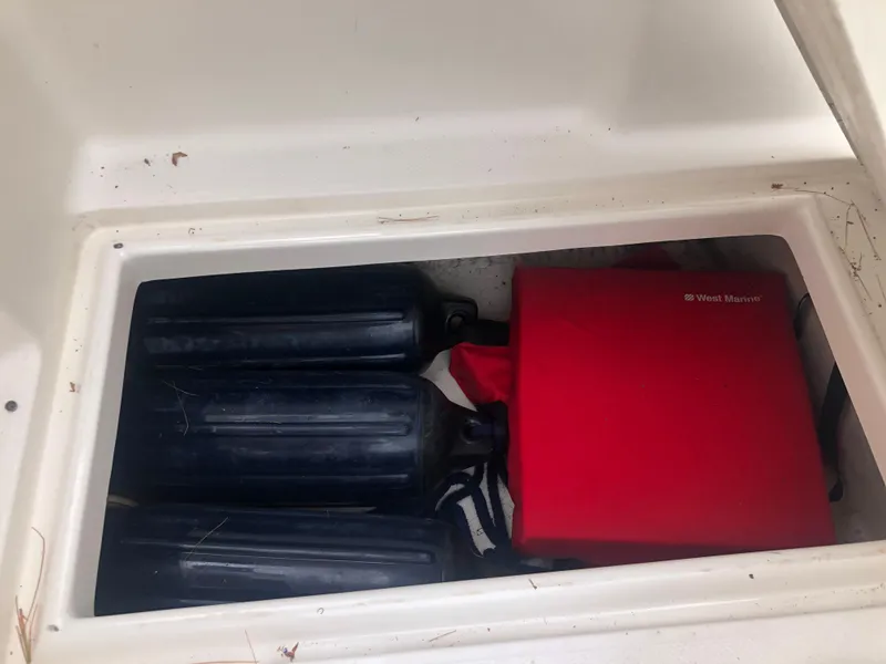 Slide: The Image of Storage compartment in 1997 Bayliner Ciera 2452 Express with fenders and red bag. - 23