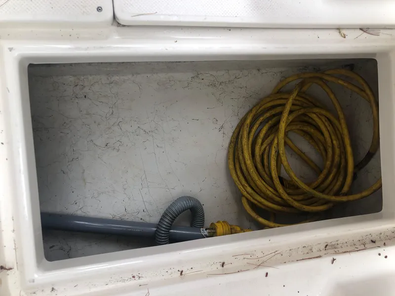Slide: The Image of Storage compartment of 1997 Bayliner Ciera 2452 Express with coiled yellow rope. - 25